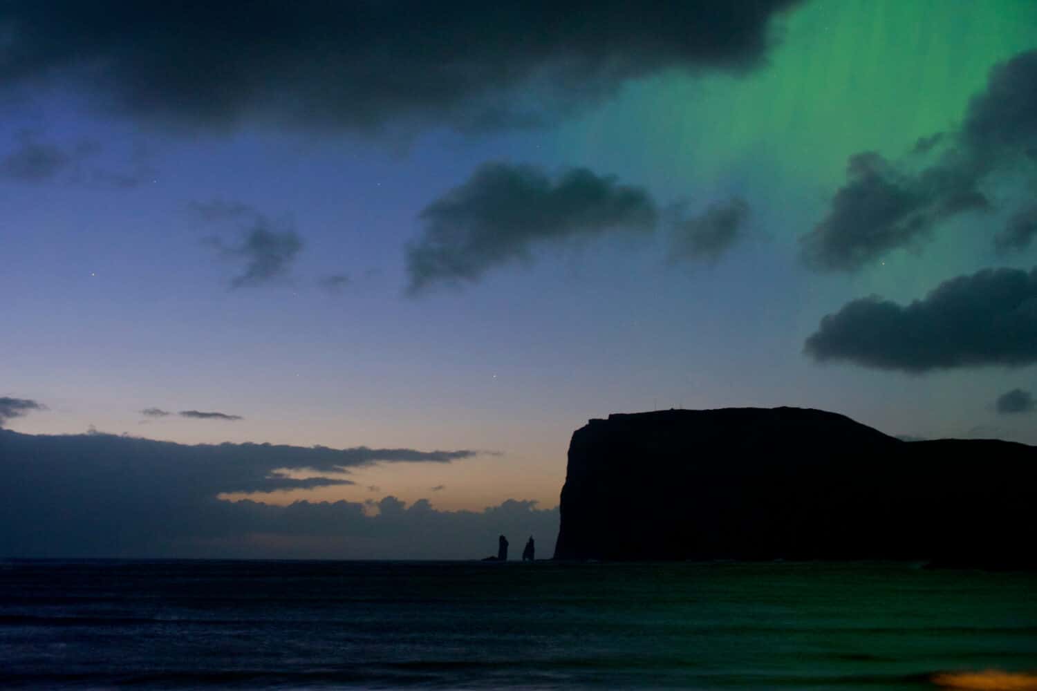 Northern Lights over the sea in the Faroe Islands town of Tjornuvik