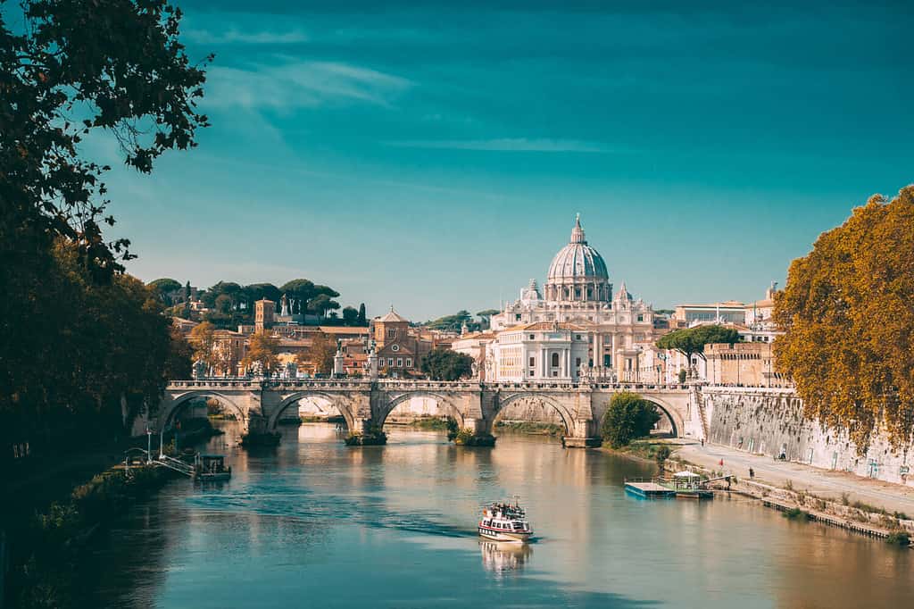 Rome, Italy. Papal Basilica Of St. Peter In The Vatican. Sightseeing Boat Floating Near Aelian Bridge. Tour Touristic Boat