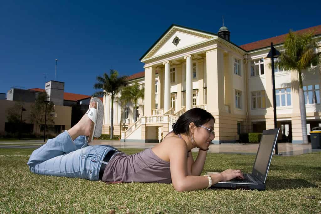 College student with laptop working outside