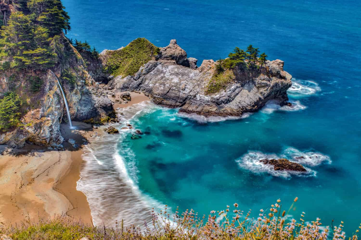 Water from McWay Falls descends on beach at the McWay Cove in Big Sur, California.