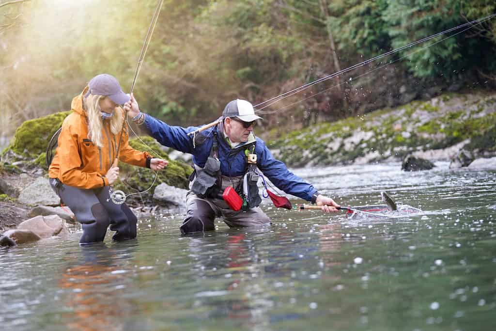 young woman learning to fly fishing with a guide