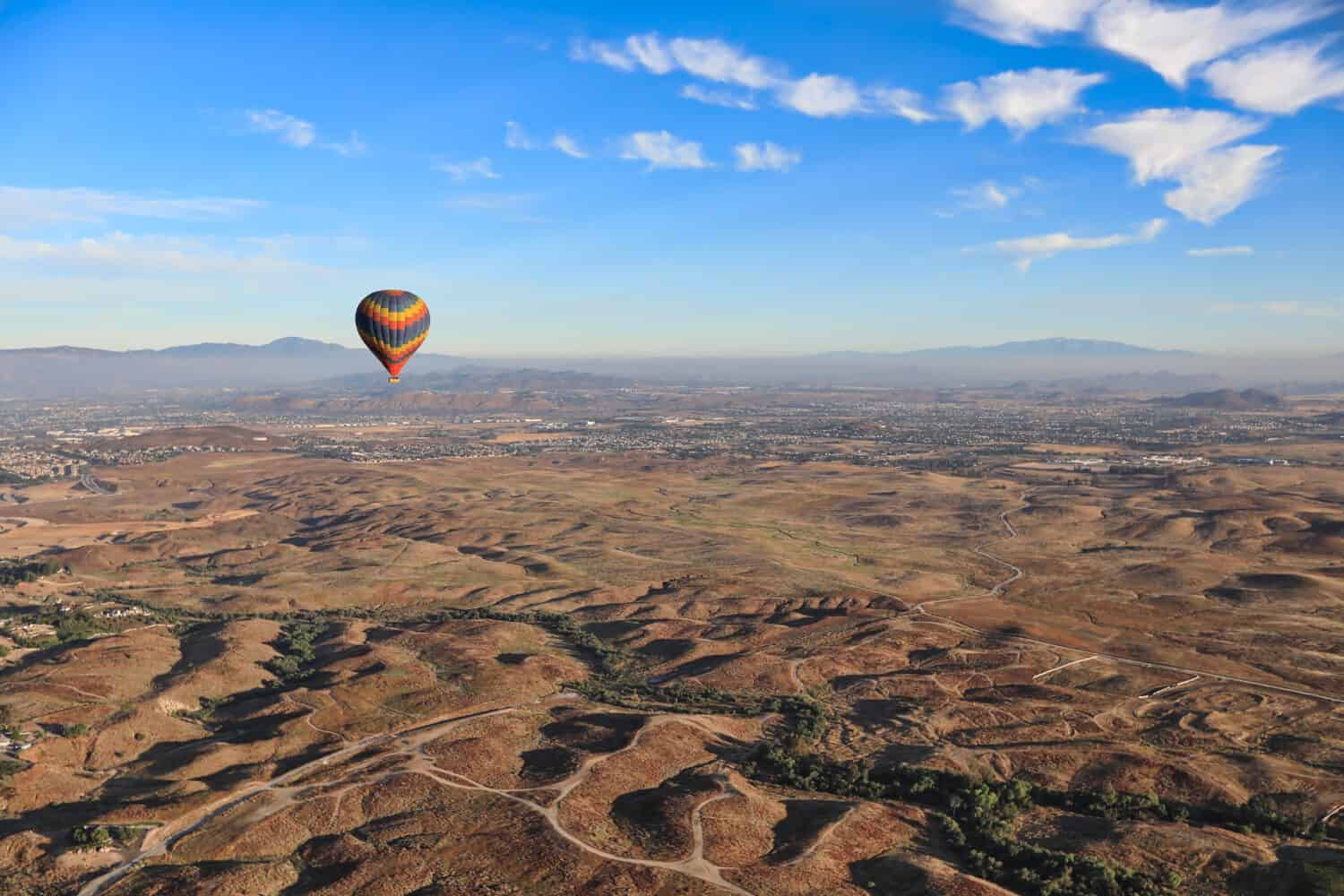 Hot air balloons fly over the grape vineyards in Temecula, California. This is a popular tourist attraction in this vacation tourism area.