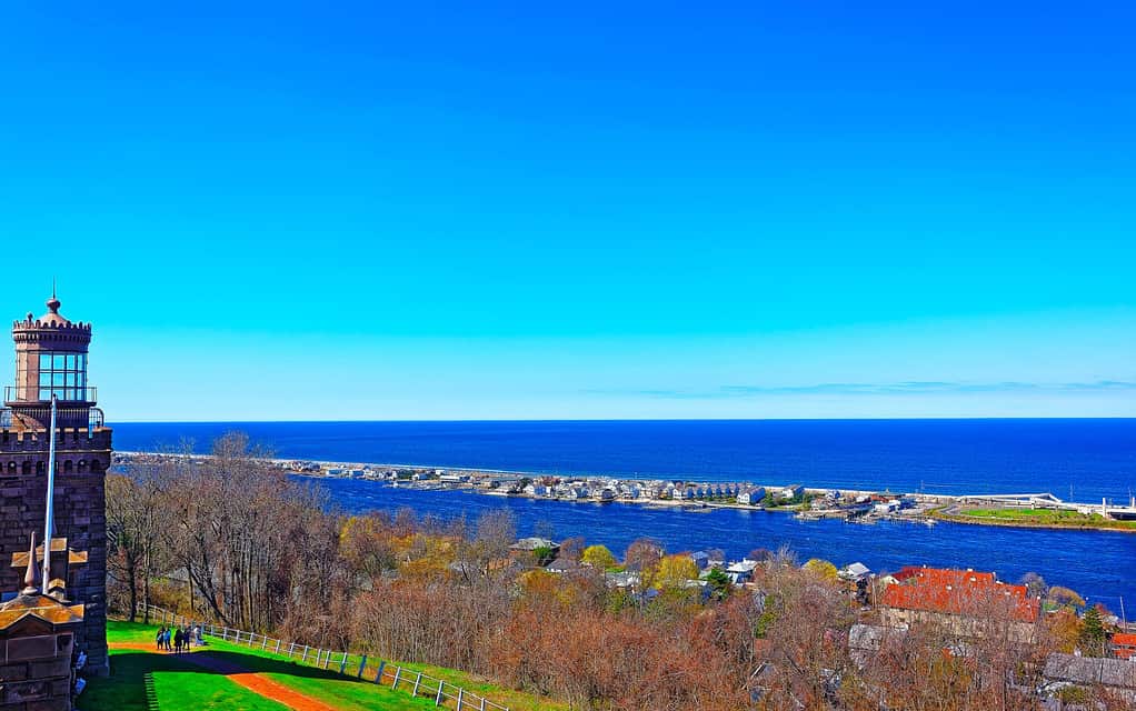 Scenery on Atlantic Ocean Bay shore at Sandy Hook. View on NYC from lighthouse, or light house. It is called Navesink Twin Lights. It is in Highlands in Monmouth County in New Jersey, USA. Blue sky