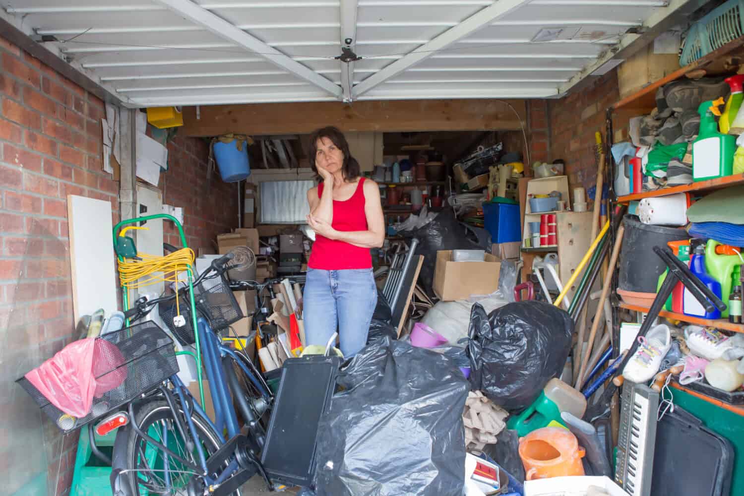 Woman looking bemused about where to start in clearing out her garage