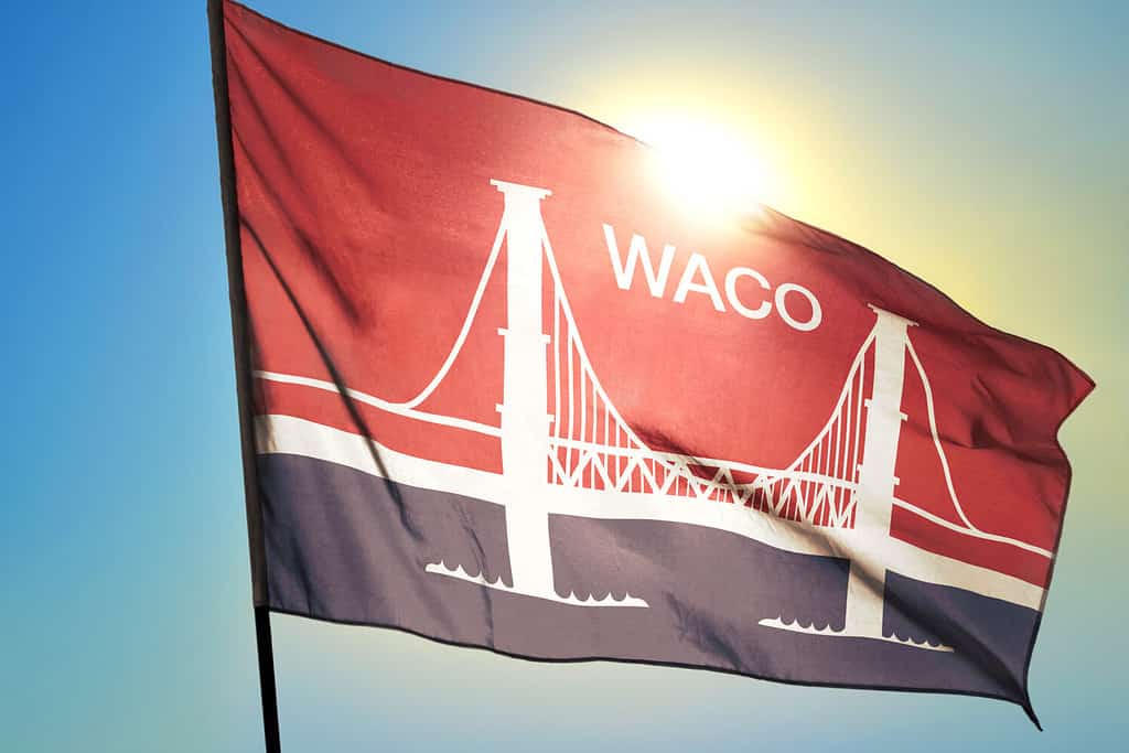 Waco of Texas of United States flag waving on the wind in front of sun