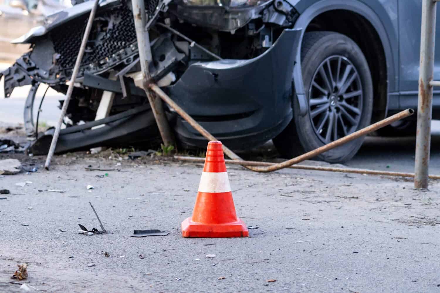 road cone against the background of a car broken in a road accident. Selective focus