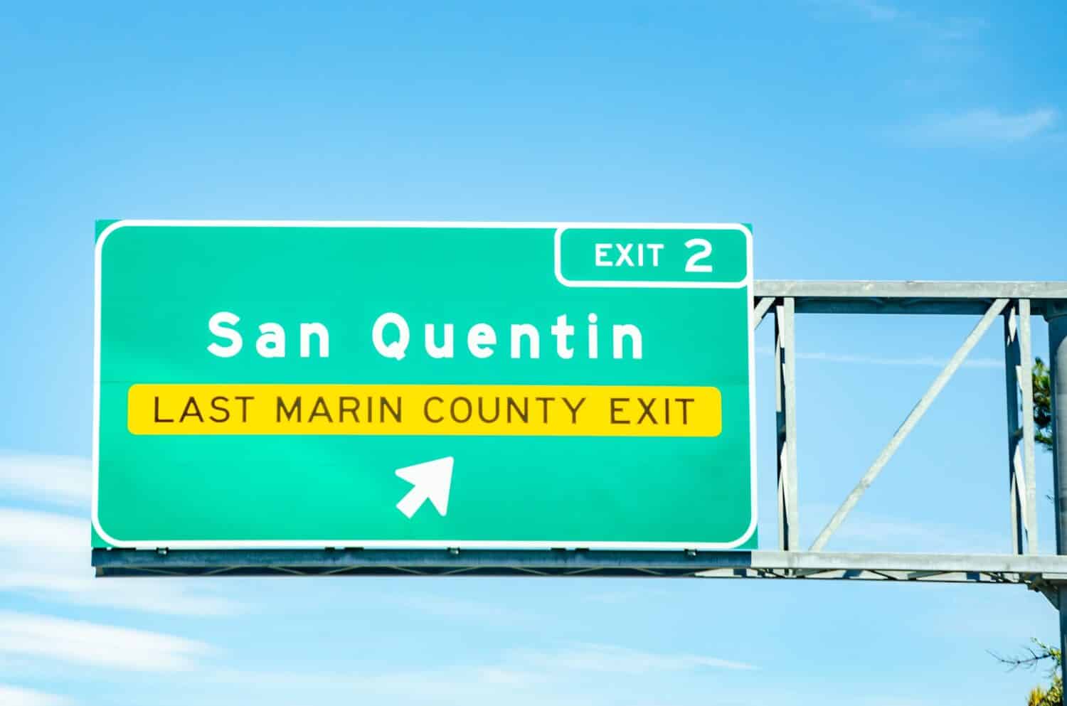 A large, green road sign informing drivers that they are approaching exit 2 for San Quentin on a highway in California, USA