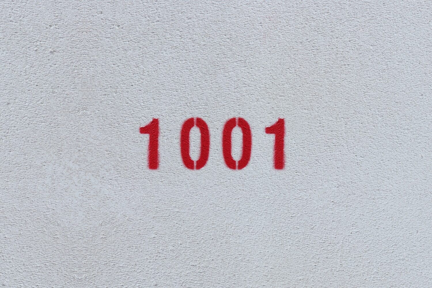 Red Number 1001 on the white wall. Spray paint.