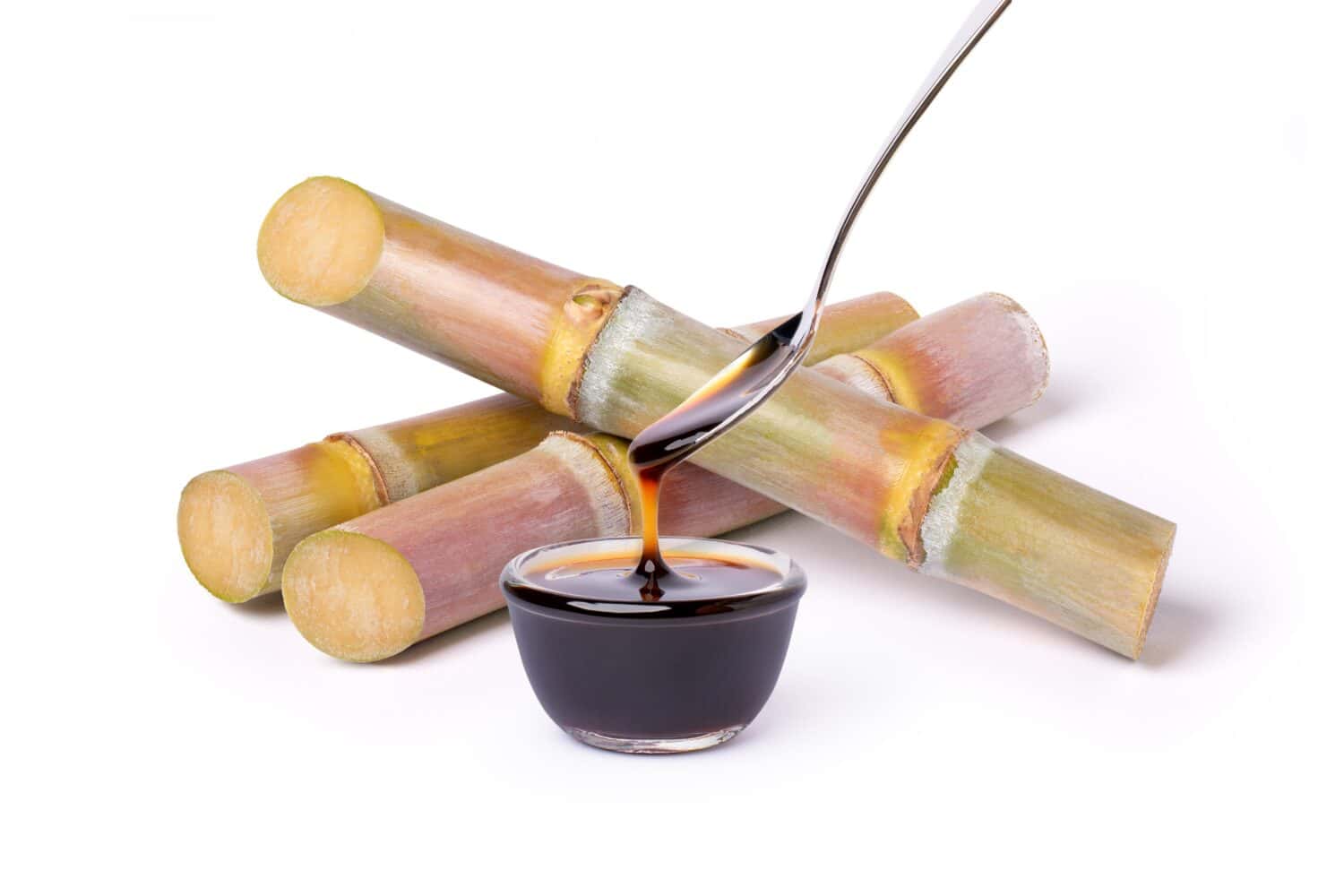 Sugar cane syrup molasses with fresh sugarcane isolated on white background.