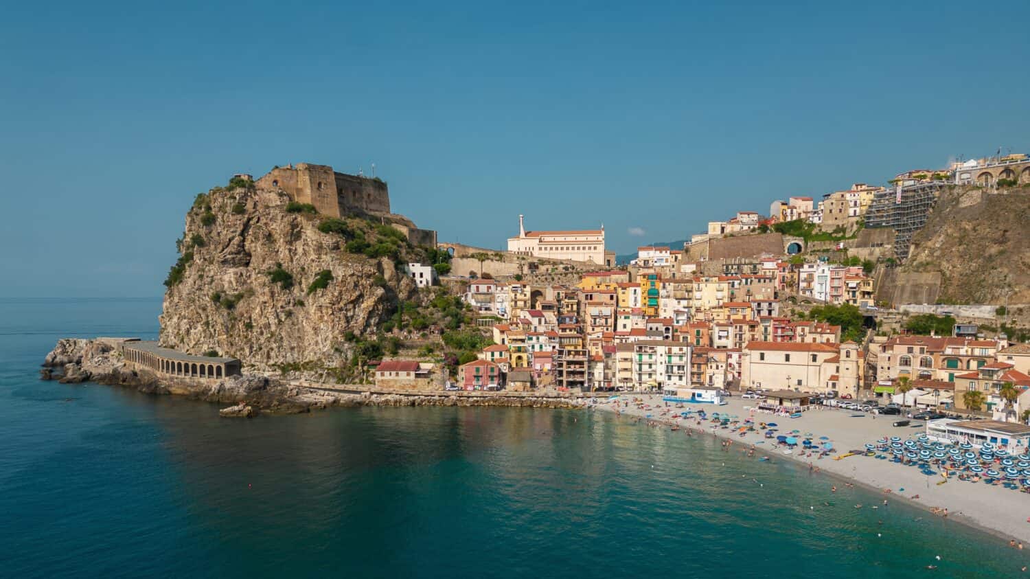 Italy, July 2023: aerial view from the drone of the medieval village of Scilla and Chianalea in Calabria, with its castle, tourist port and houses directly on the sea with its restaurants on stilts