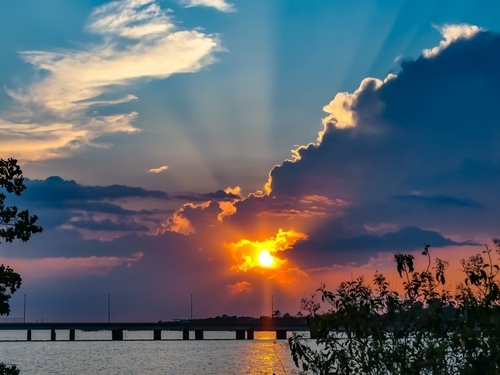 Beautiful sunset over Lake Pontchartrain and the causeway bridge. Colorful reflections in water.