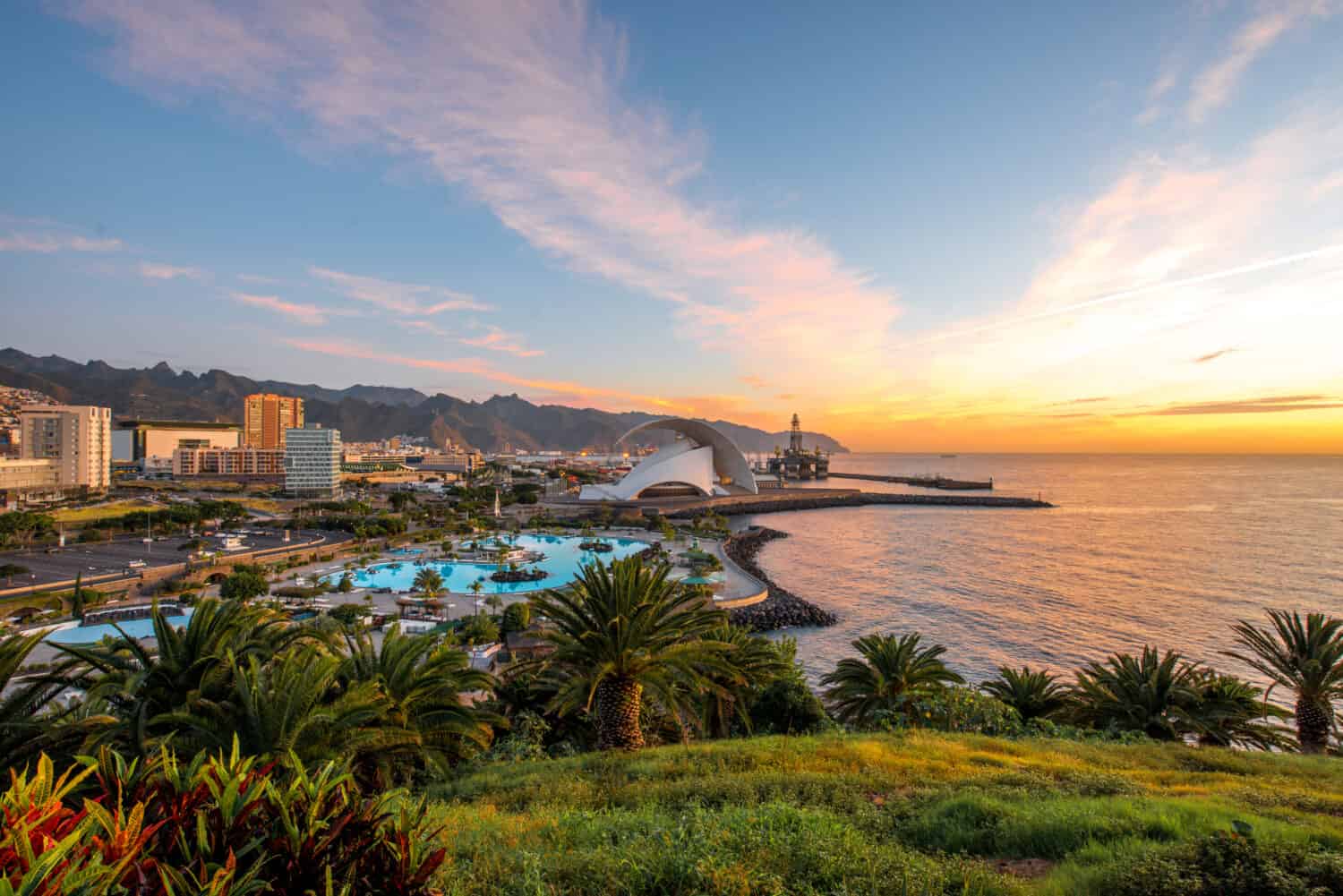 Santa Cruz cityscape view with park, ocean and mountains on the background on the sunrise, Canary islands, Spain
