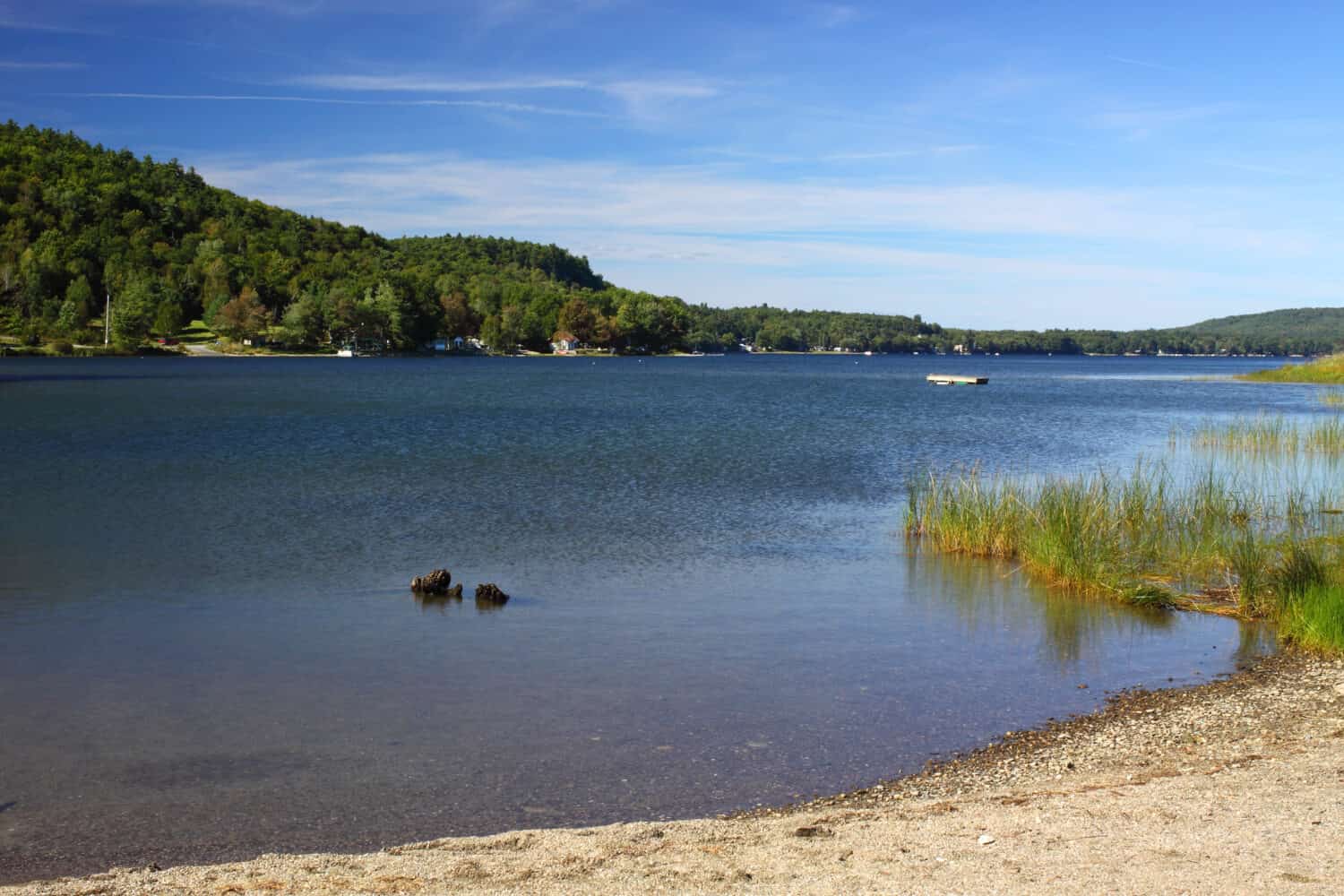 View of Swan lake in Swanville, Maine with vivid blue sky.