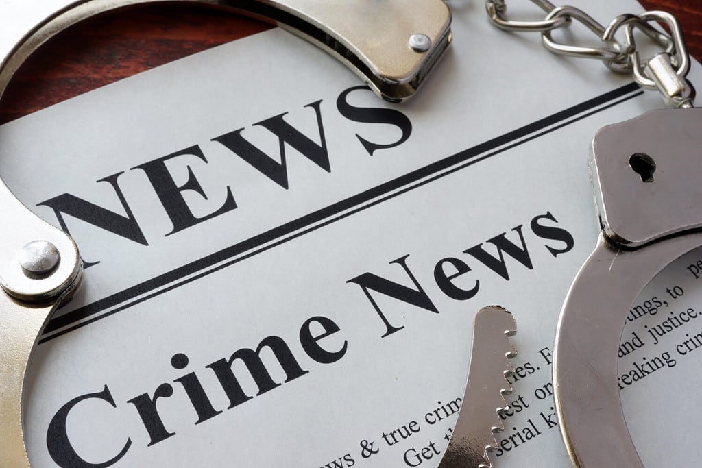 Newspaper with title crime news and handcuffs.