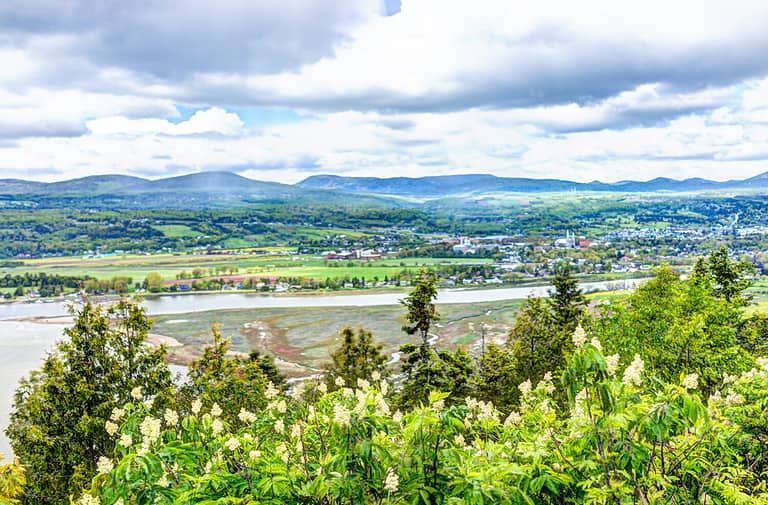 Baie-Saint-Paul in Quebec, Canada cityscape or skyline with buildings, mountains on coast and Saint Lawrence river