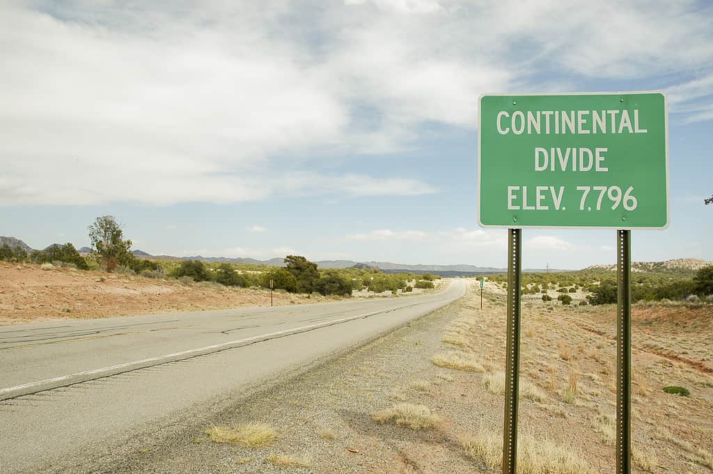 Continental Divide green highway sign on the side of a two lane highway.