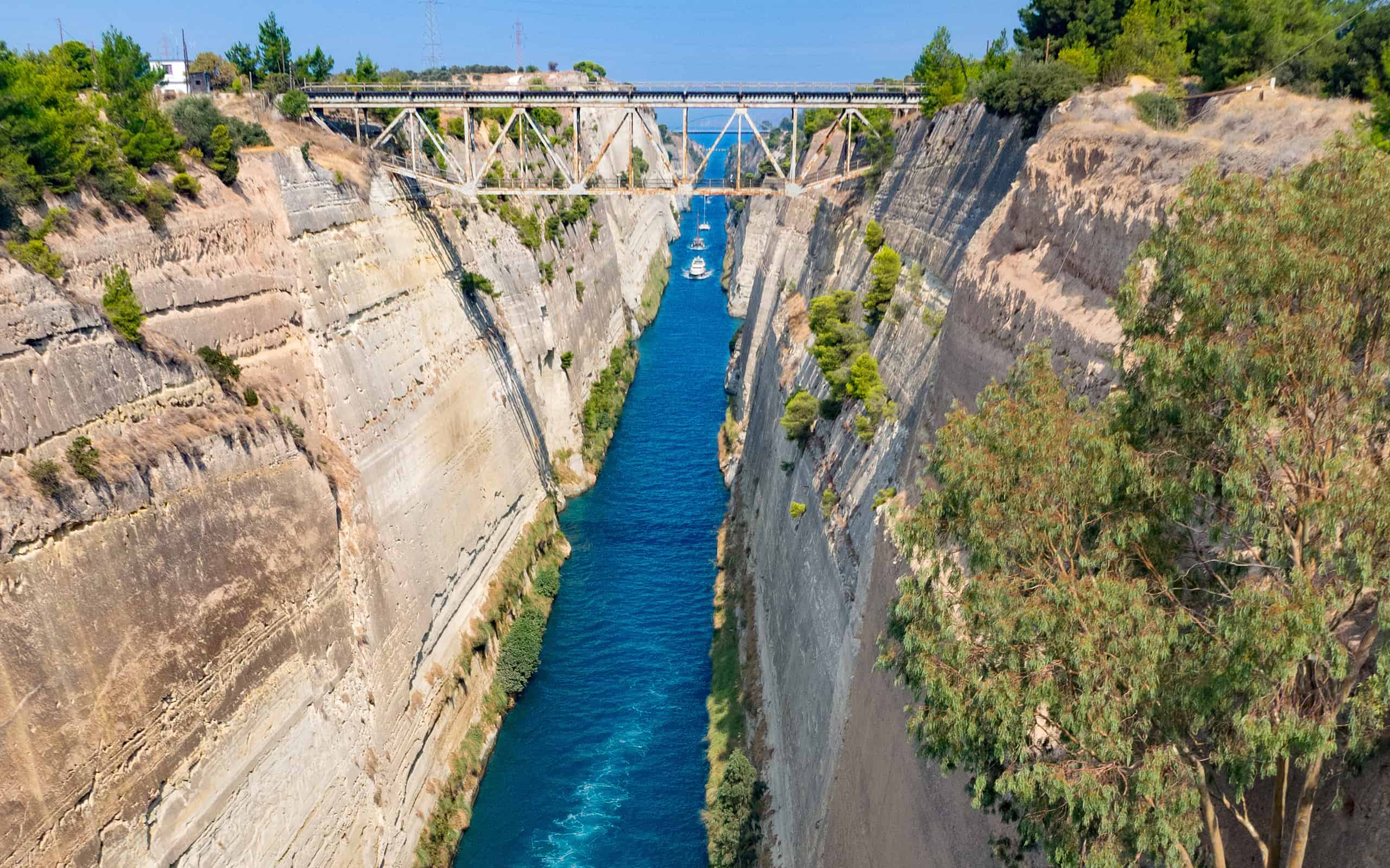 View from the bridge to the boats and View from the bridge to the boats and yachts passing through the Corinth Canal from a sunny day on Peloponnese in Greece
