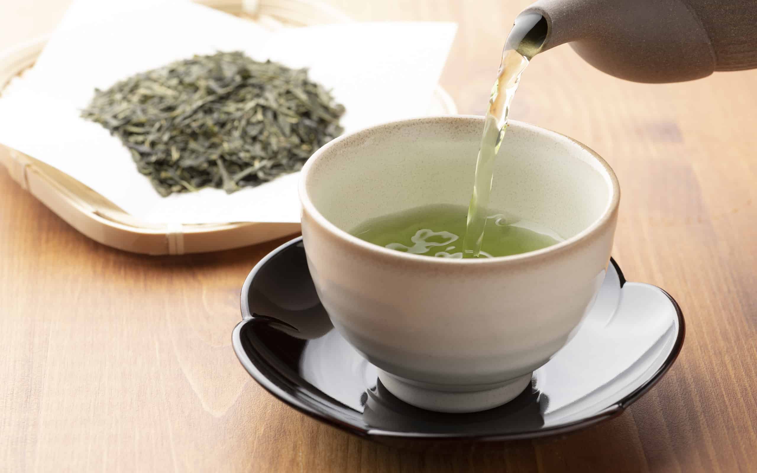 Warm green tea on a wooden table.
