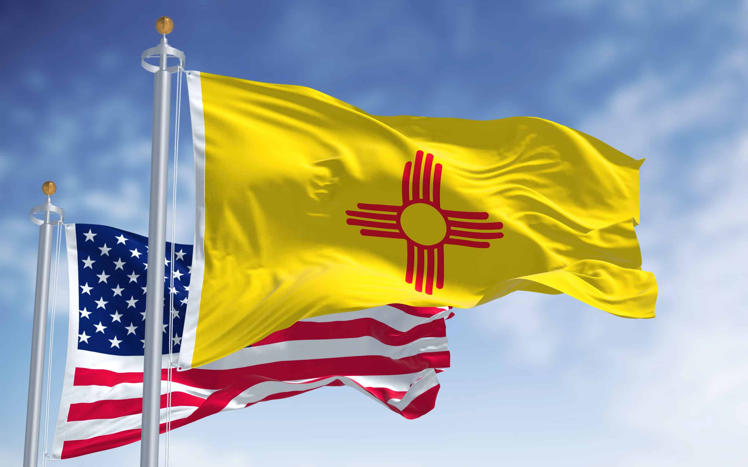 The New Mexico state flag waving along with the national flag of the United States of America