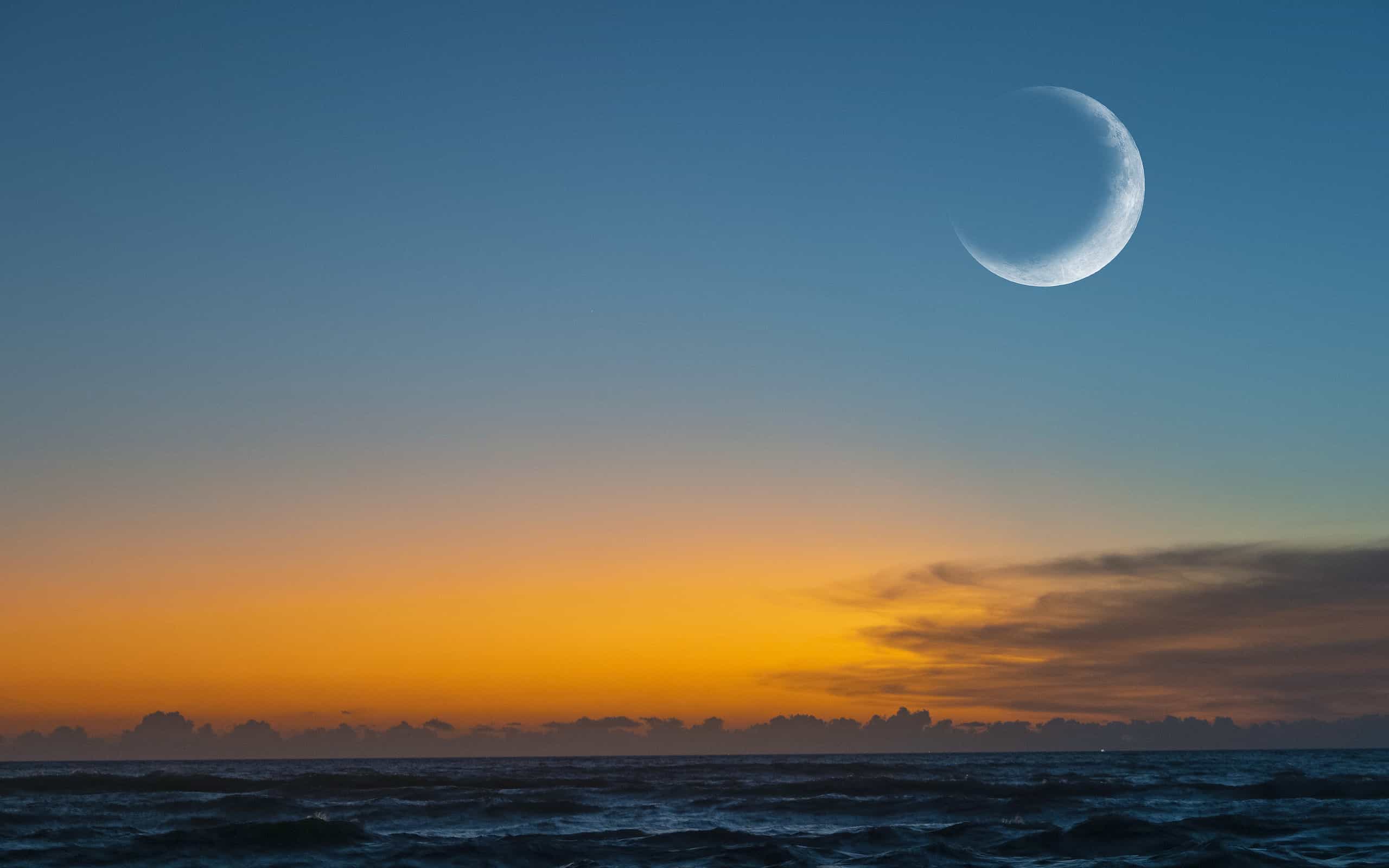 New moon or Ð¡rescent above ocean. Half Moon on bright evening sky, space for text
