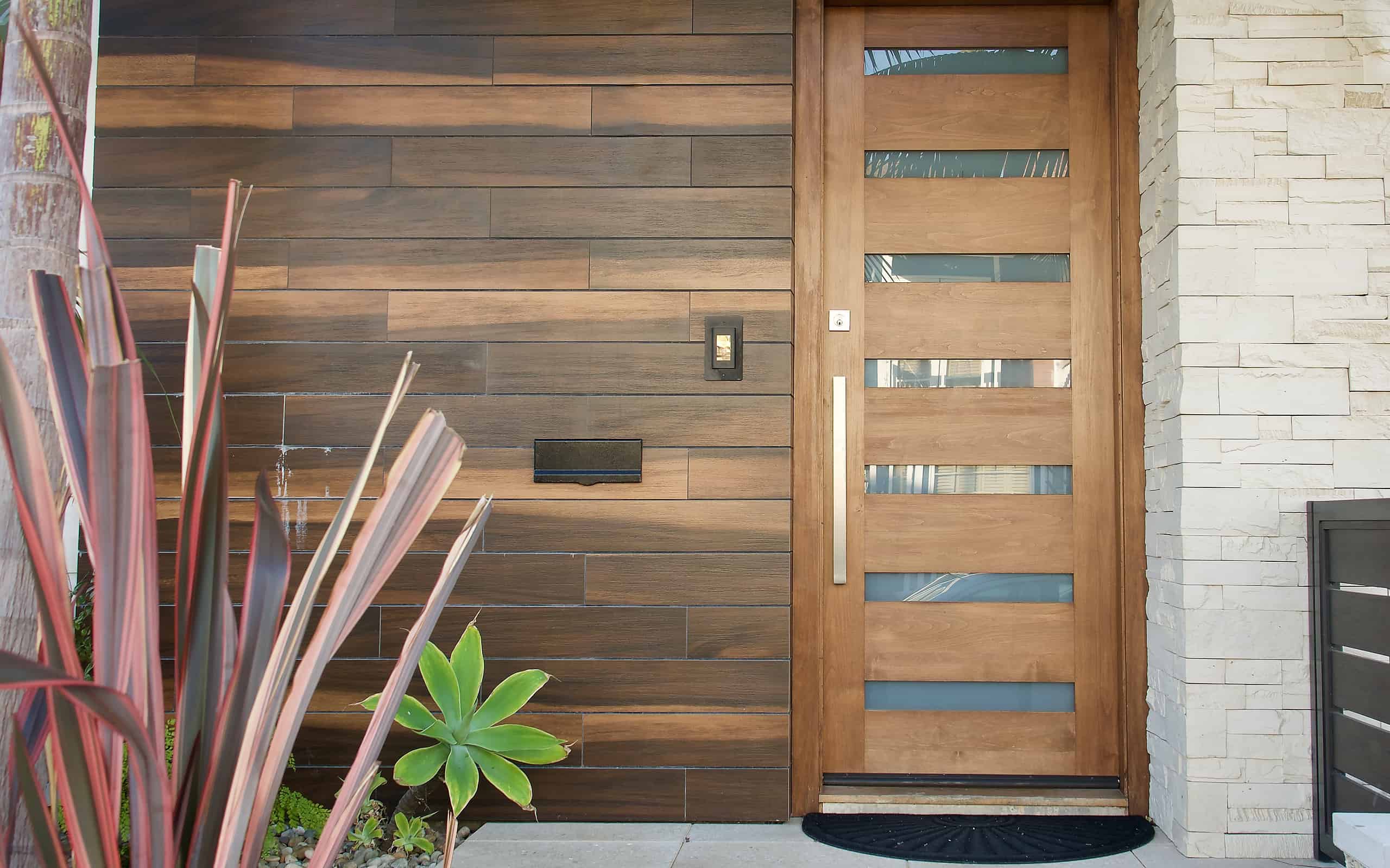 traditional home with modern front door made of glass and wood