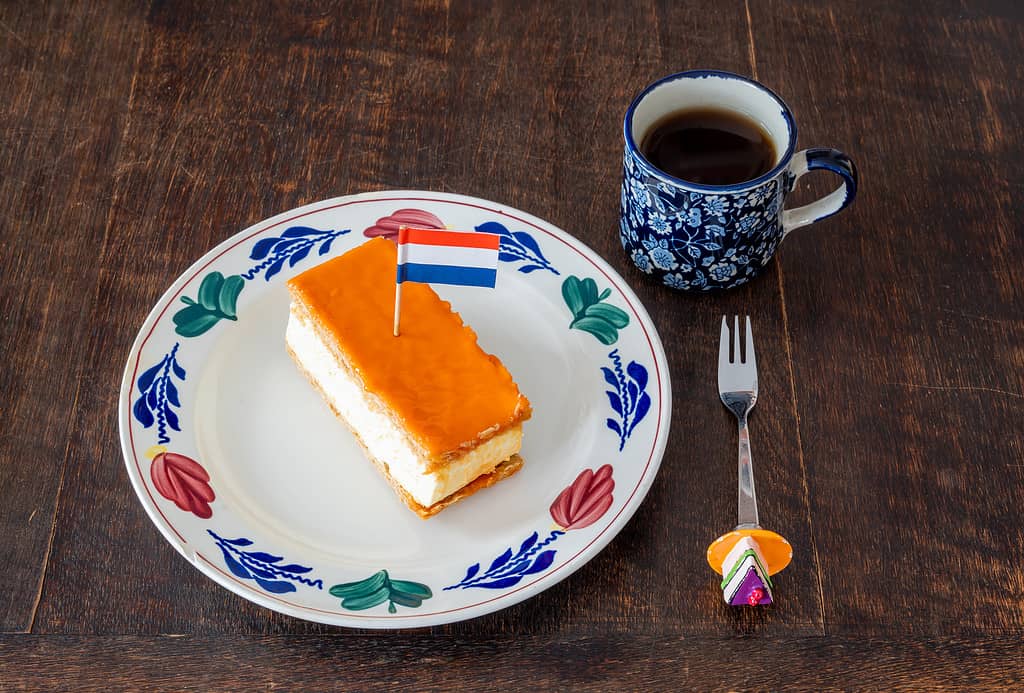 Traditional dutch pastry called Tompouce with orange top layer and dutch flag, which is typically eaten during King's Day celebrations