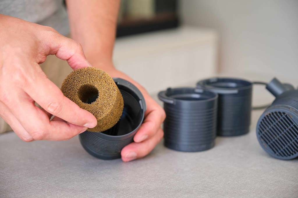 Man hand setting up new filter foam for his aquarium at home.