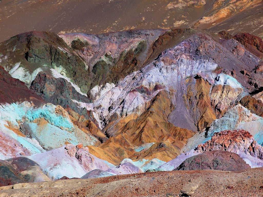 Multicolored rock of the Artist Drive Formation - eroded and colorful desert hills, aprons of pink, green, purple, brown, and black rock debris drape across the mountain front, the result of the oxidation of iron, copper, manganese and other minerals; located in Death Valley National Park, California, USA