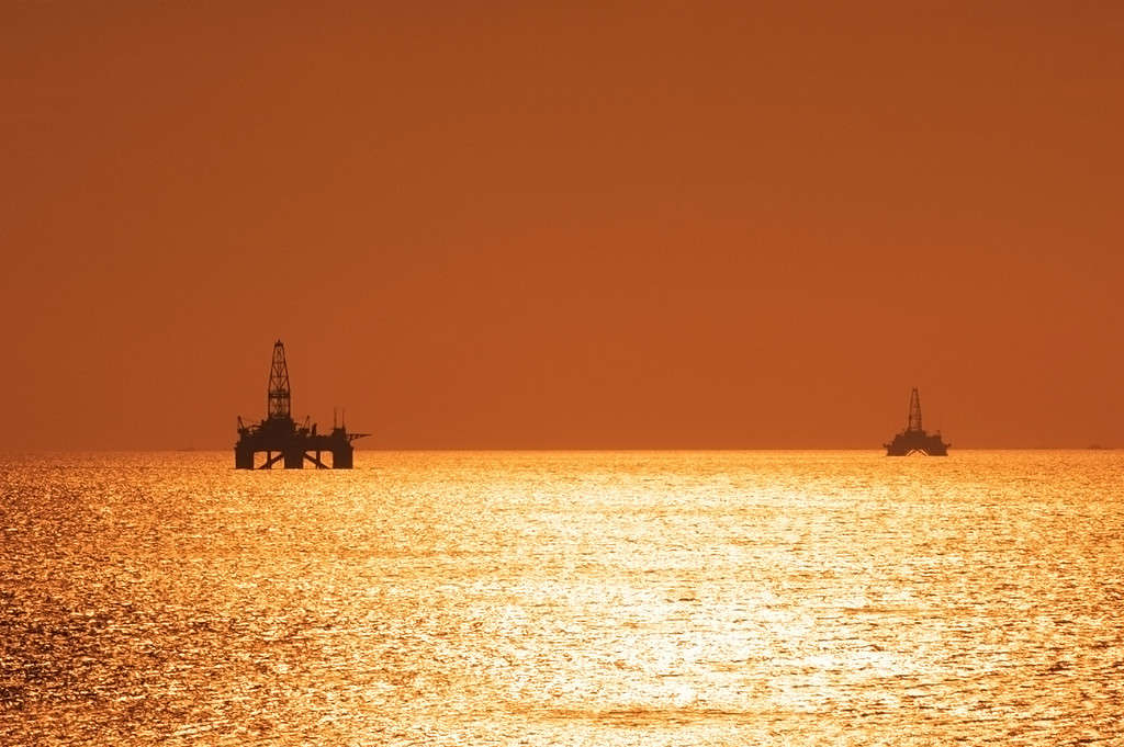 Two offshore oil rigs during sunset in Caspian se