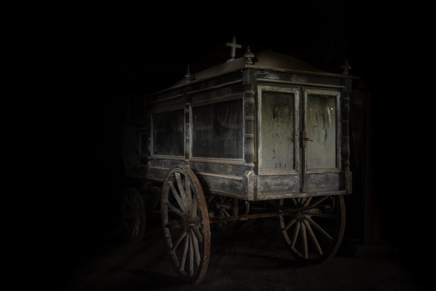Very old and dusty hearse stage made of wood, with large wooden wheels. Used to transport the coffin with the dead during the funeral in the late 18-th century.