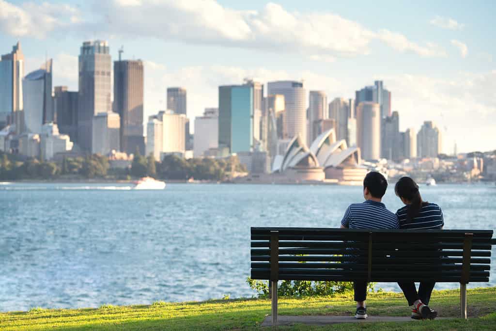 Asian couple sit and relax after running in a park in sydney, Australia