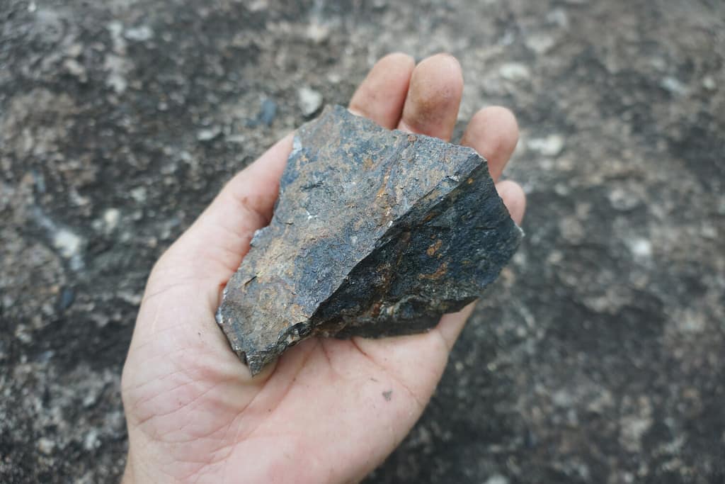 A hand holding Hematite stone. iron stone.