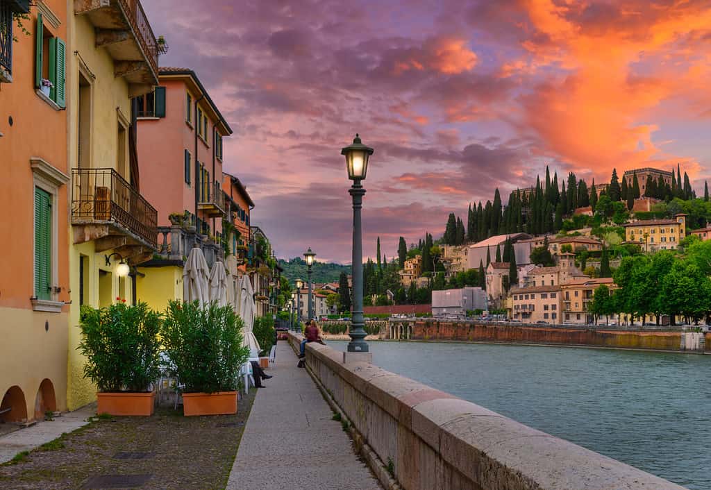 Embankment of Adige river in Verona, Italy. Sunset cityscape of Verona. Architecture and landmark of Verona