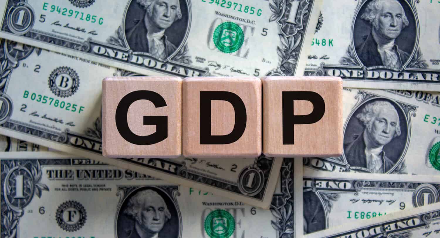 GDP symbol. Concept word 'GDP, gross domestic product' on cubes on a beautiful background from dollar bills. Business and GDP, gross domestic product concept. Copy space.