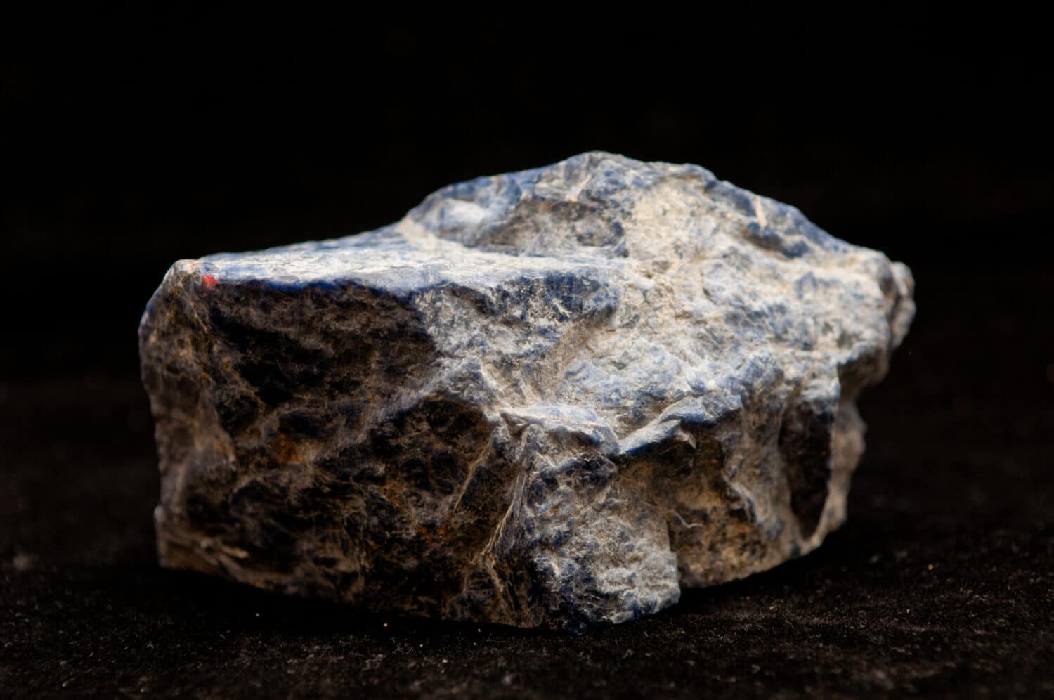 blue lazurite rare earth mineral on a black background