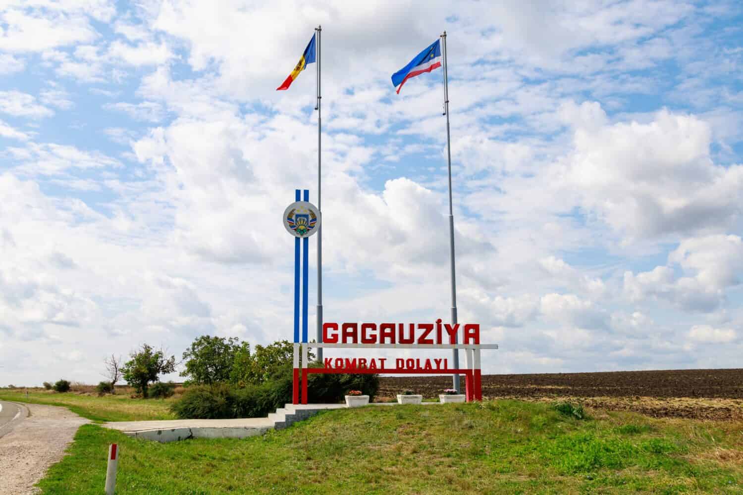 The inscription in the Gagauz language GAGAUZIA KOMRAT DISTRICT. Welcome to Gagauzia, Moldova. Flags of Moldova and Gagauzia. Background