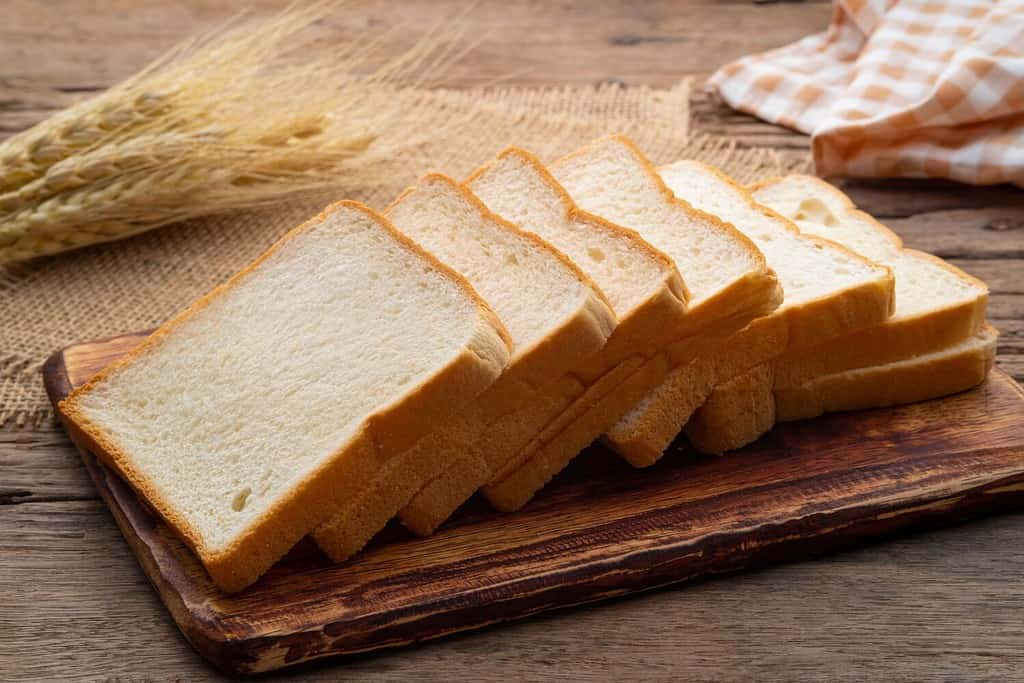 Sliced white bread on wooden board