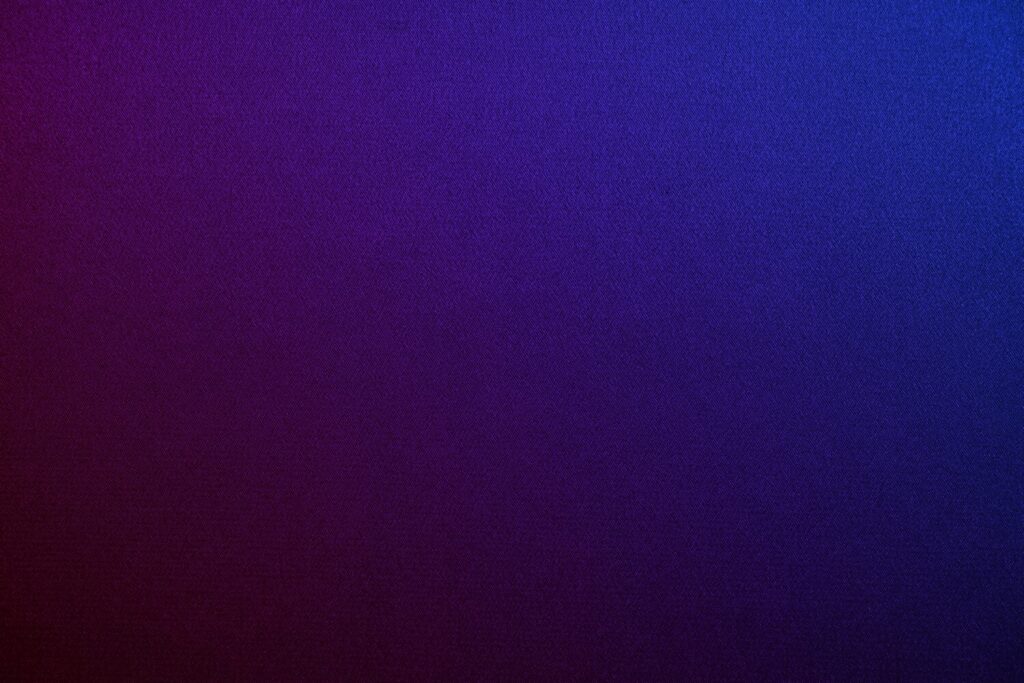 Deep purple blue abstract background. Gradient. Toned fabric surface texture. Dark colorful background with space for design. Combination of plum eggplant color and navy blue.