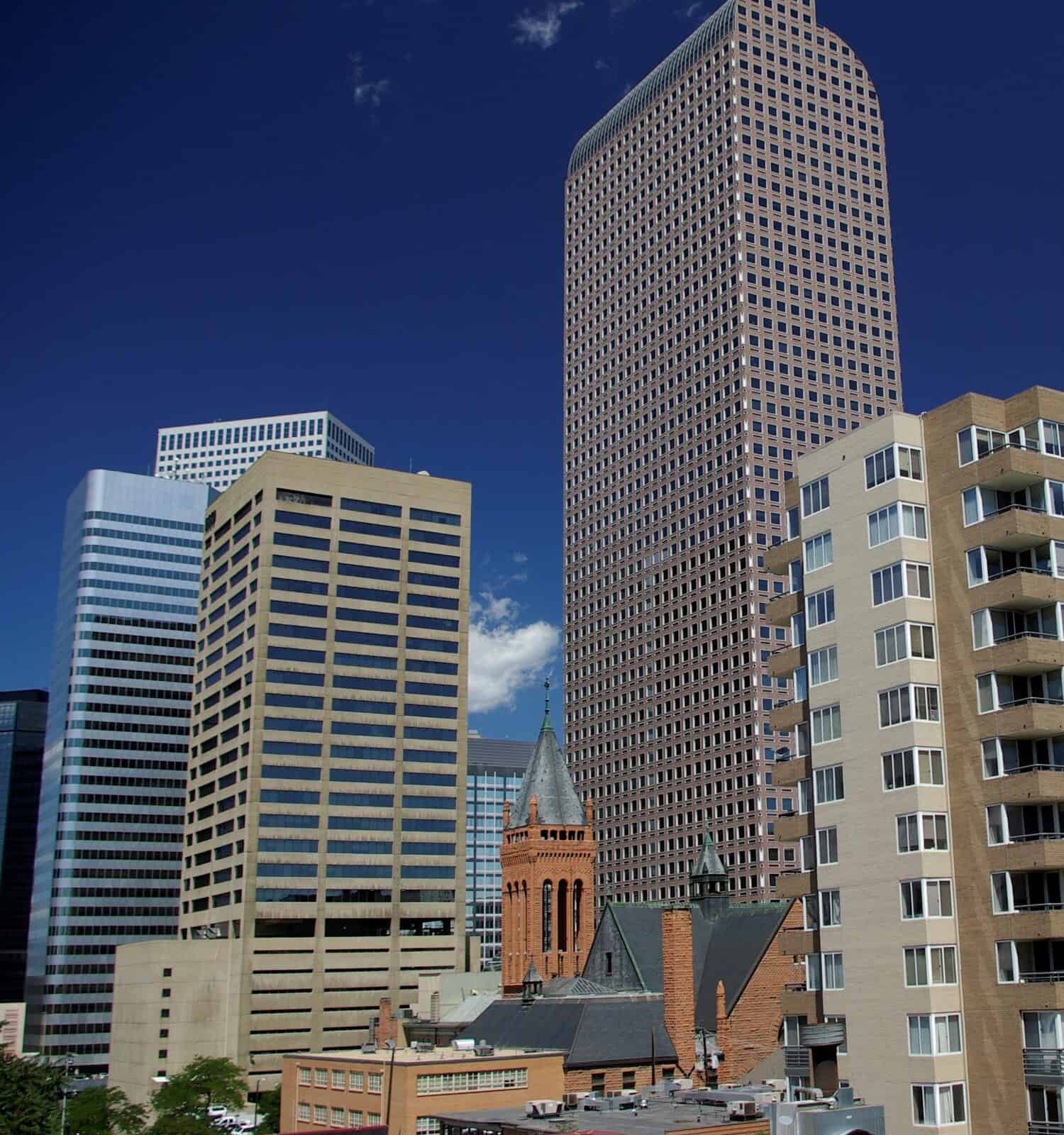 A cityscape of the Mile High City - Denver capturing the iconic Wells Fargo Center on a sunny and clear-sky day.