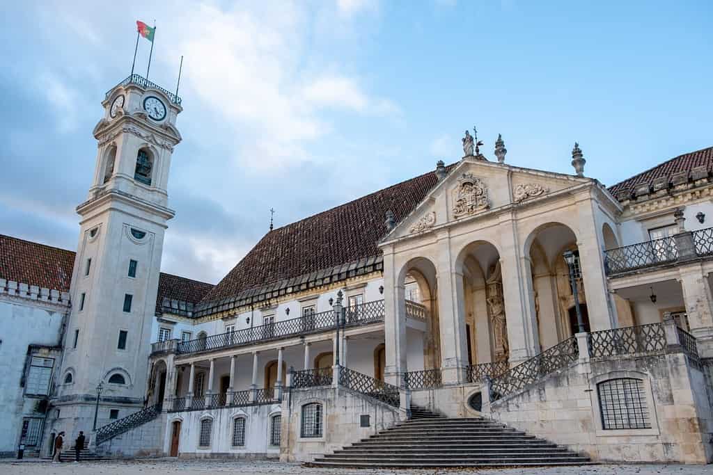 Coimbra, Portugal, 01.12.2019: Facade of the Faculty of Law "Faculdade de Direito" and the Clock Tower at the Campus of the University of Coimbra.