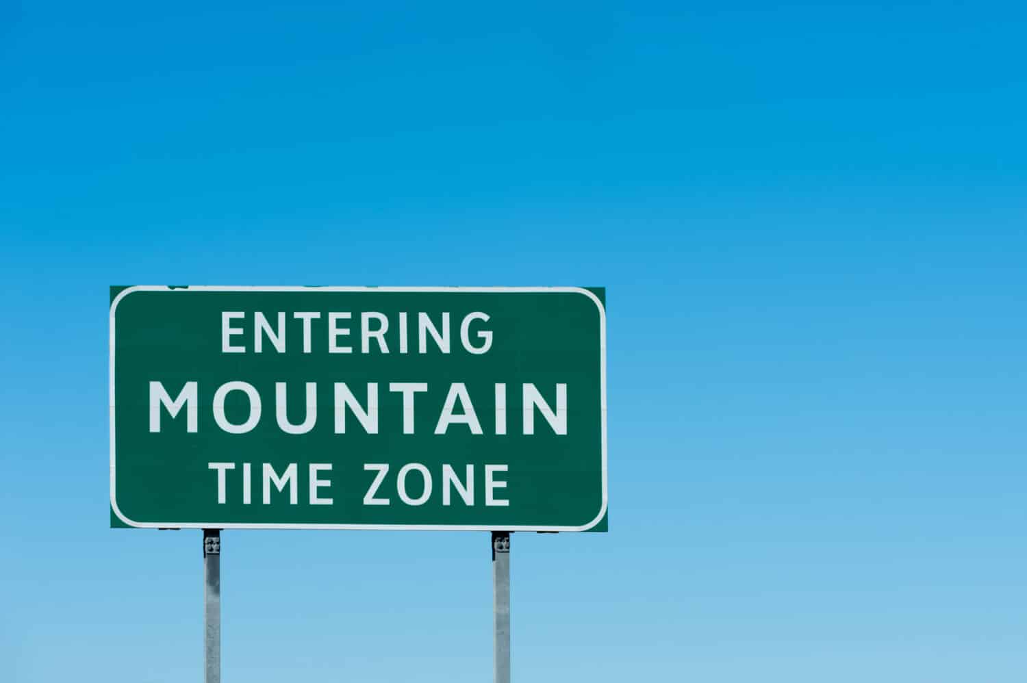 Road sign with Mountain time zone, New Mexico