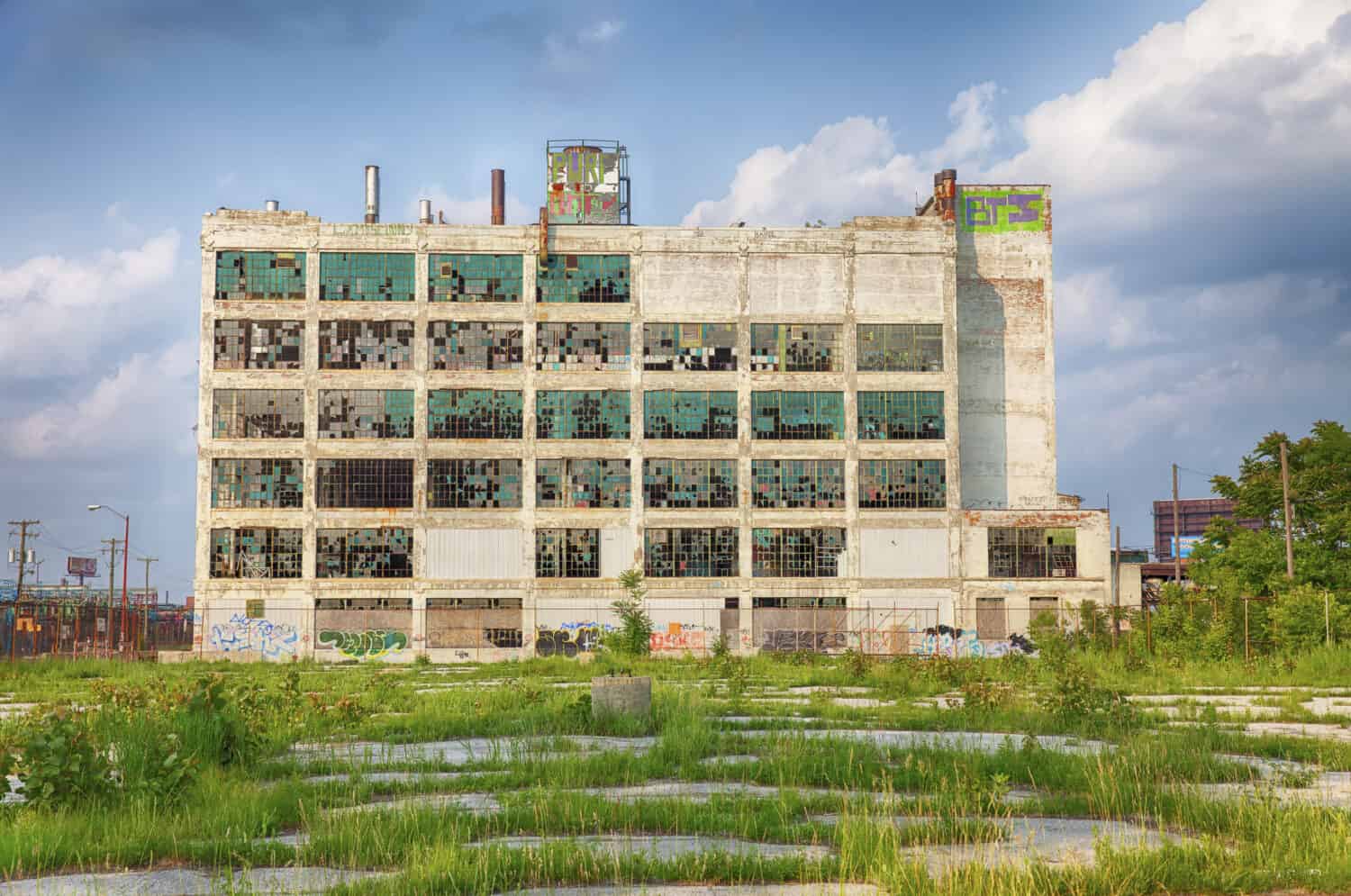 An old factory in the Highland Park area shows the post-industrial plight of Detroit with broken windows and a parking lot filled with weeds.