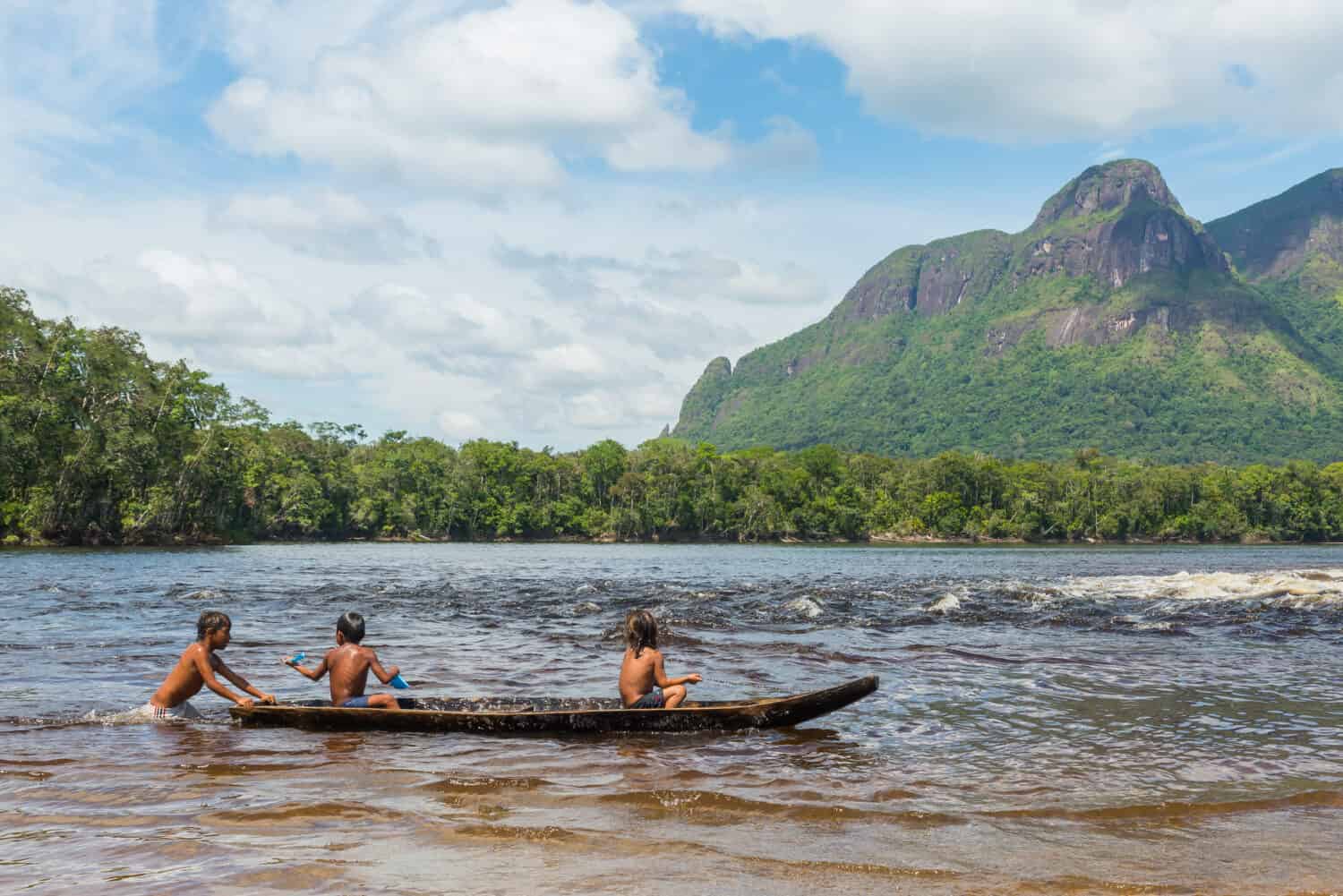 Children from the Piaroa ethnicity play on a canoe in the waters of the Autana river, in the amazonas state, in southern Venezuela