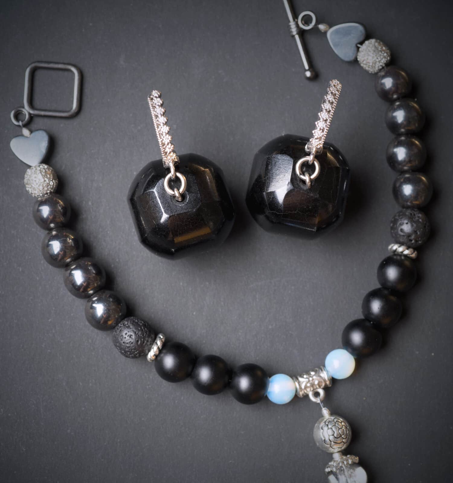 jewel handmade bracelet with semipreciouse stones and earrings with black  semiprecious gem jet at black background