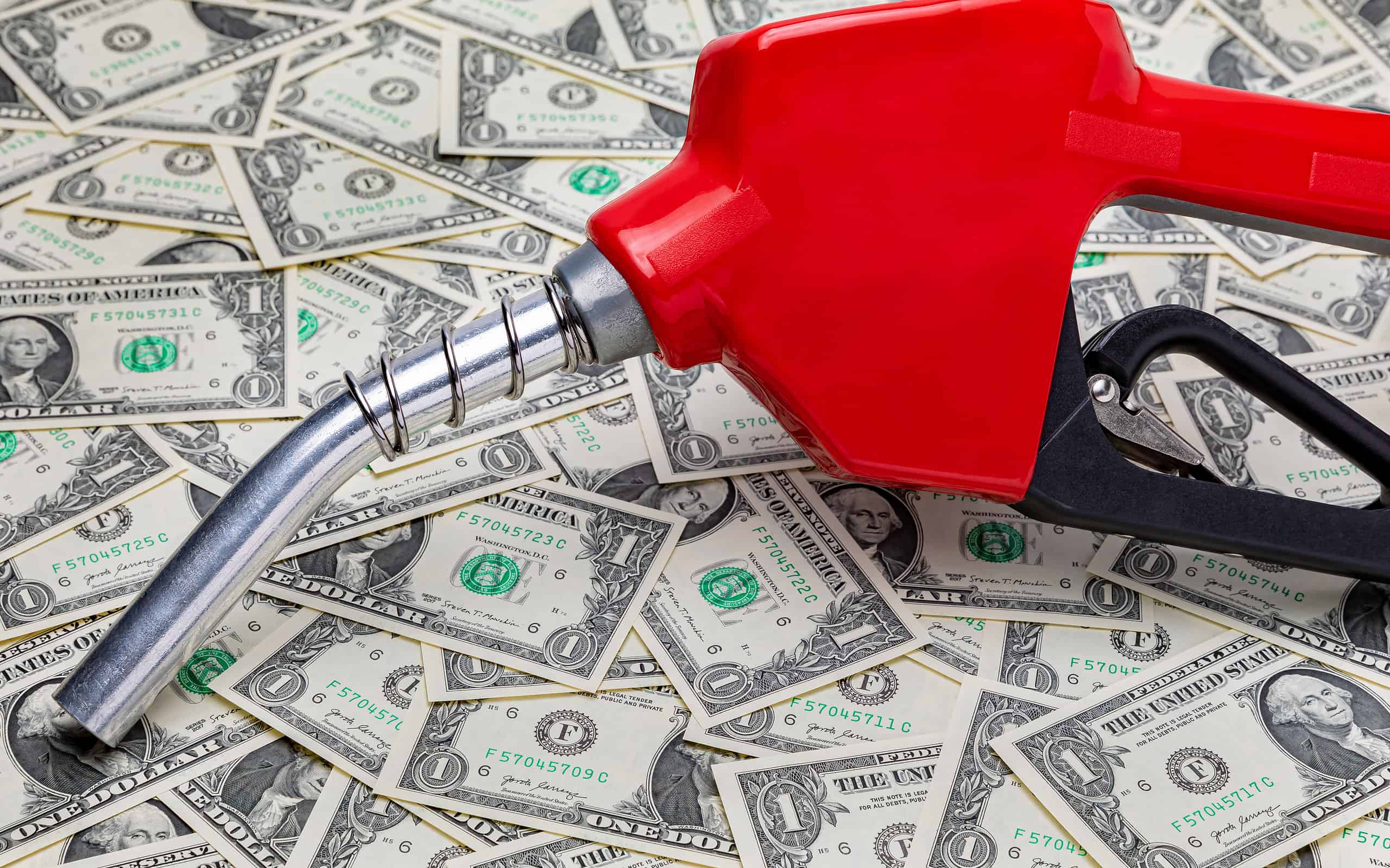 Gasoline fuel nozzle and cash money. Gas price, tax, ethanol and fossil fuel concept