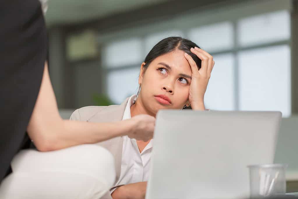Woman looking at her coworker with a displeased expression, woman working in her office