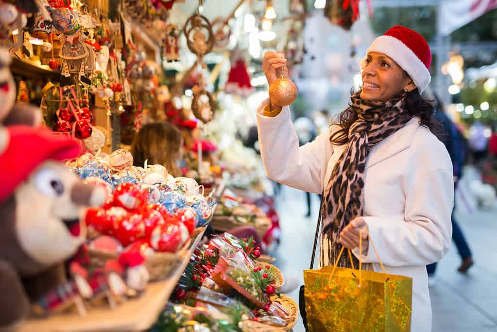 Positive woman selecting gifts at christmas fair