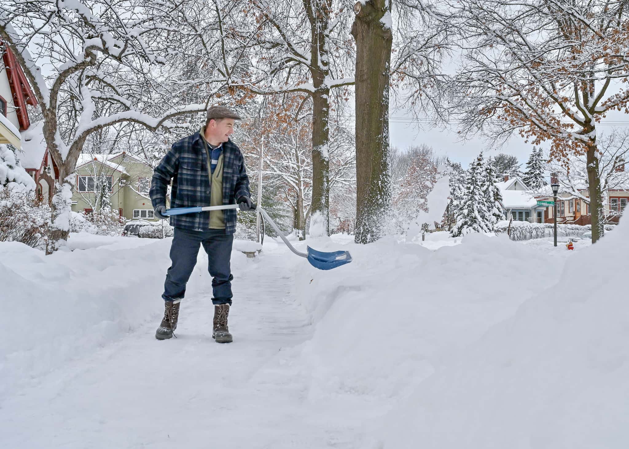 A man shoveling sidewalk in the morning