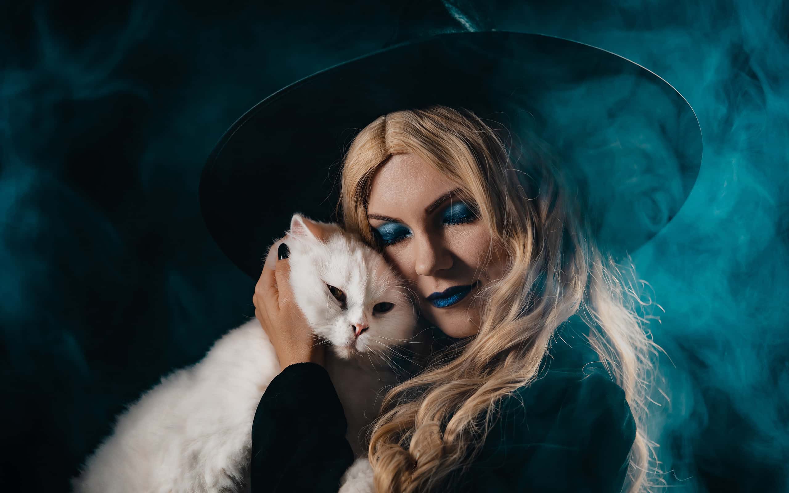 Pretty witch with white furry magic cat on dark background. Happy Halloween, masquerade costume, trick or treat, classic hag