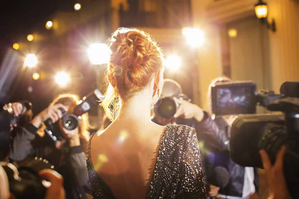 Celebrity being photographed by paparazzi photographers at event